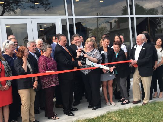 people gathered outside of Ascentra Credit Union cutting a bright orange ribbon at their Ribbon Cutting Ceremony