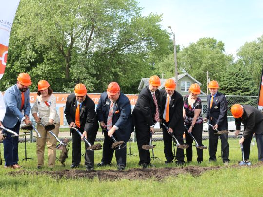 group digging in orange hard hats at Ascentra Credit Union's groundbreaking