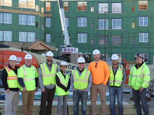 Project team in front of Overlook Village under construction