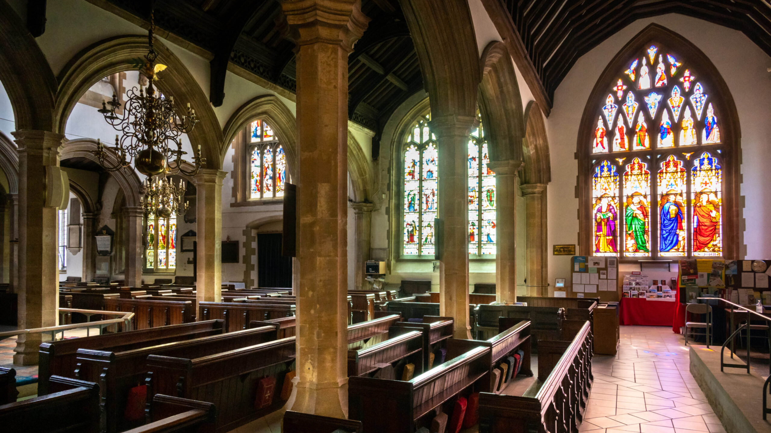 chapel pews with stained glass windows and pillars