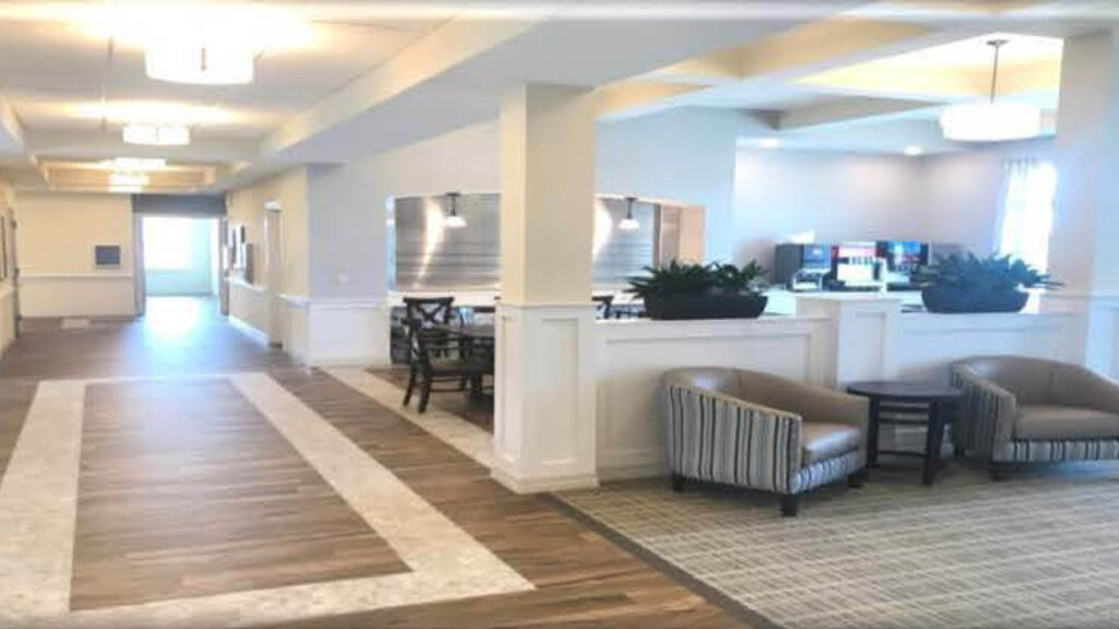 lobby with plush chairs and a dining area in the background