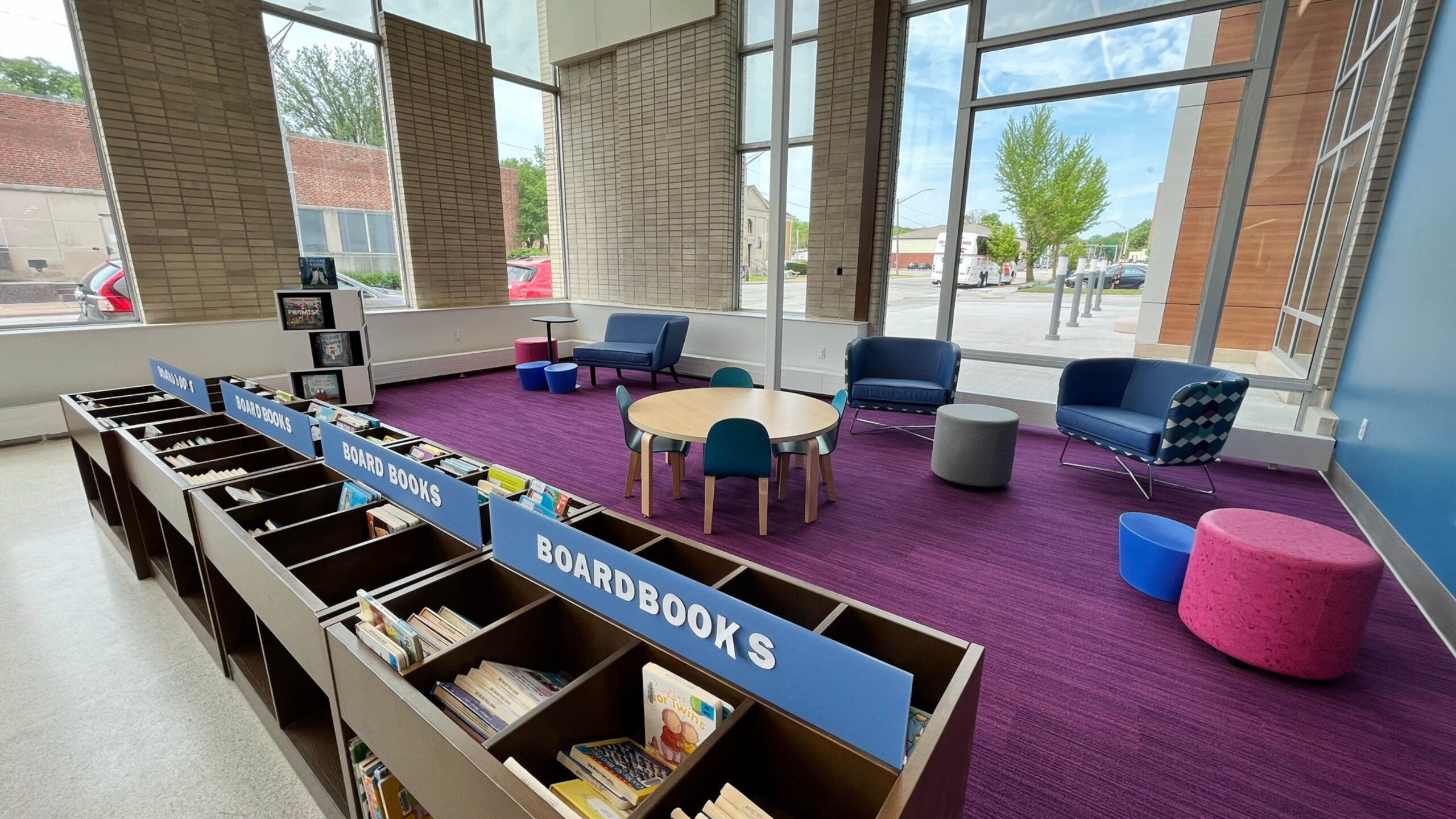 kids area of a library with tables and chairs and bookshelves