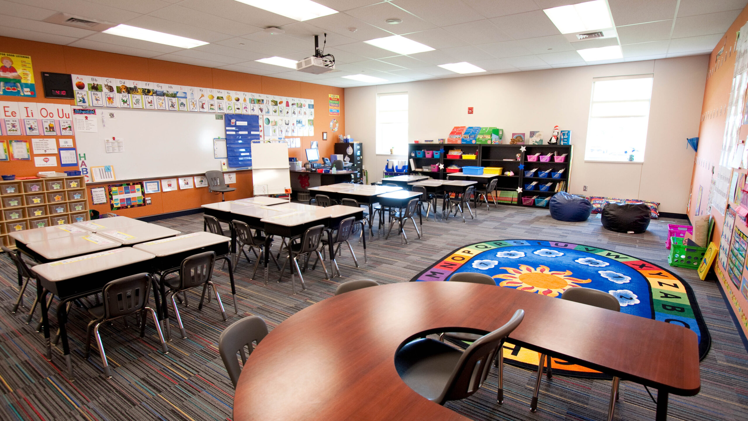classroom with tables and chairs and a rug
