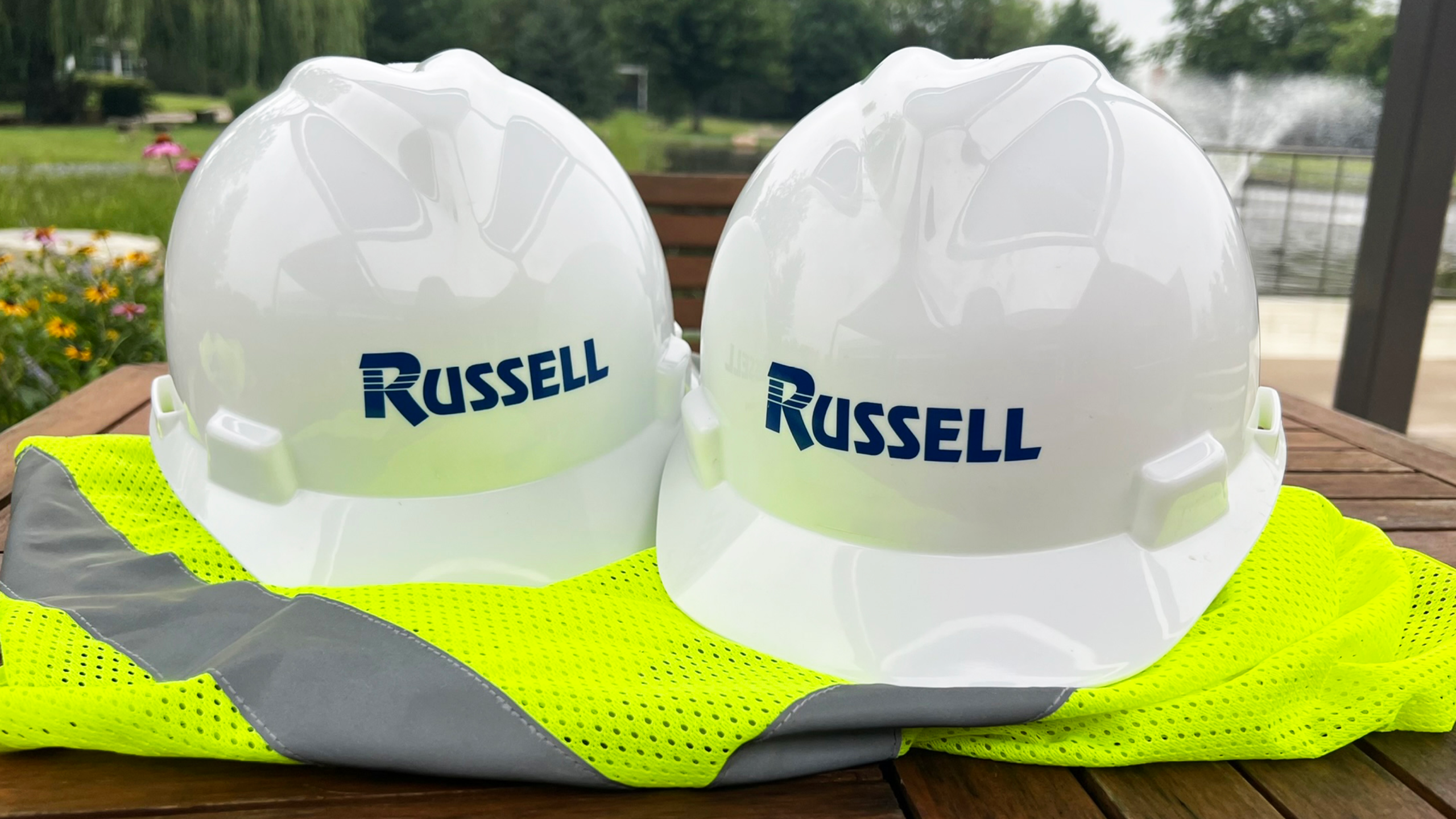 Two Russell hard hats on top of a safety vest.