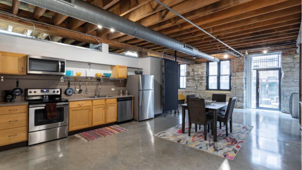 loft kitchen with cabinetry, appliances, and a dining set