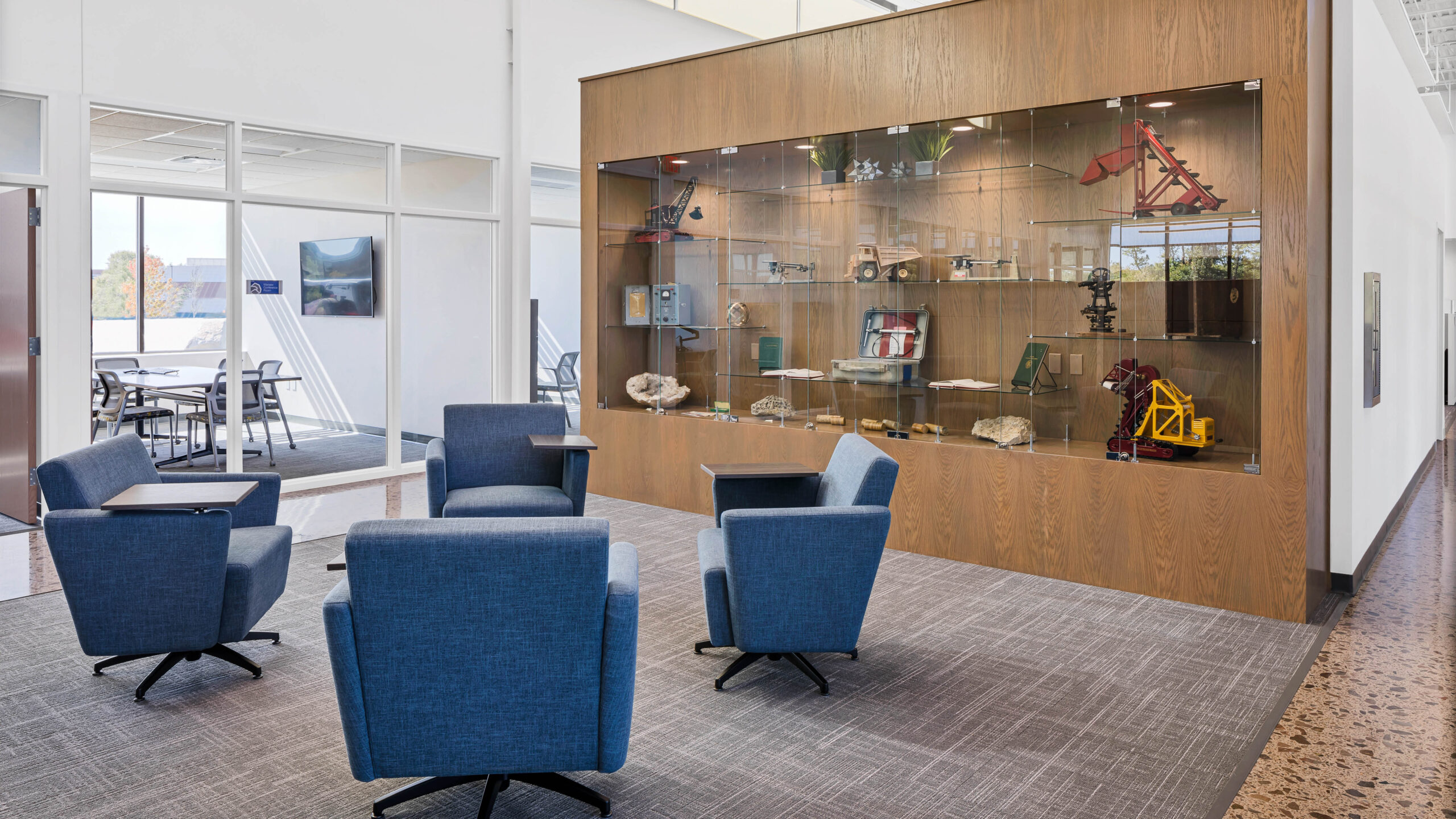 meeting space with plush chairs and display case