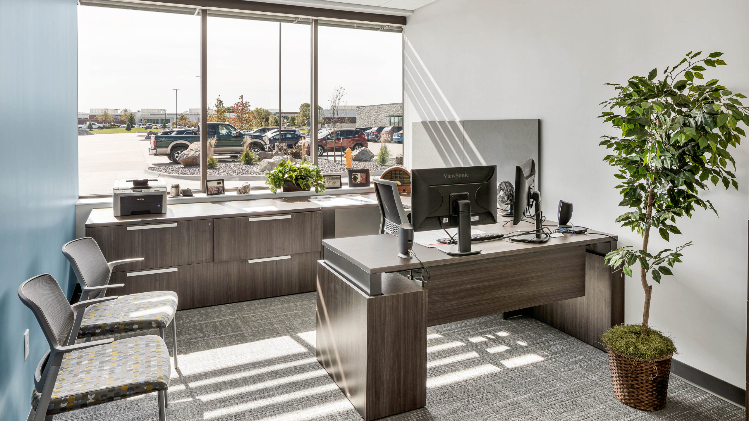 private office with desk, chairs, and a large window