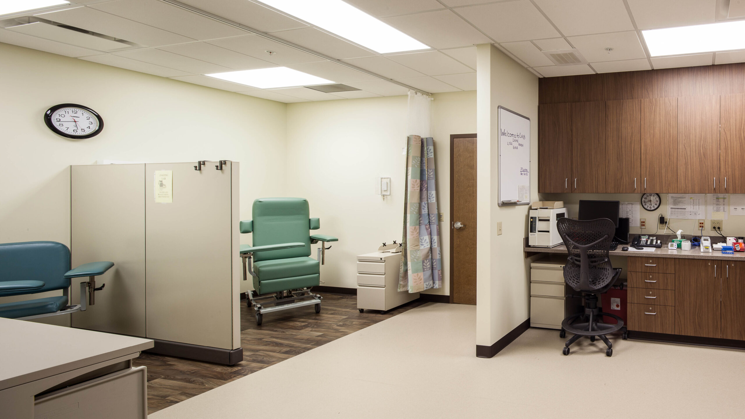 medical room with patient chairs, dividers, and cabinet space