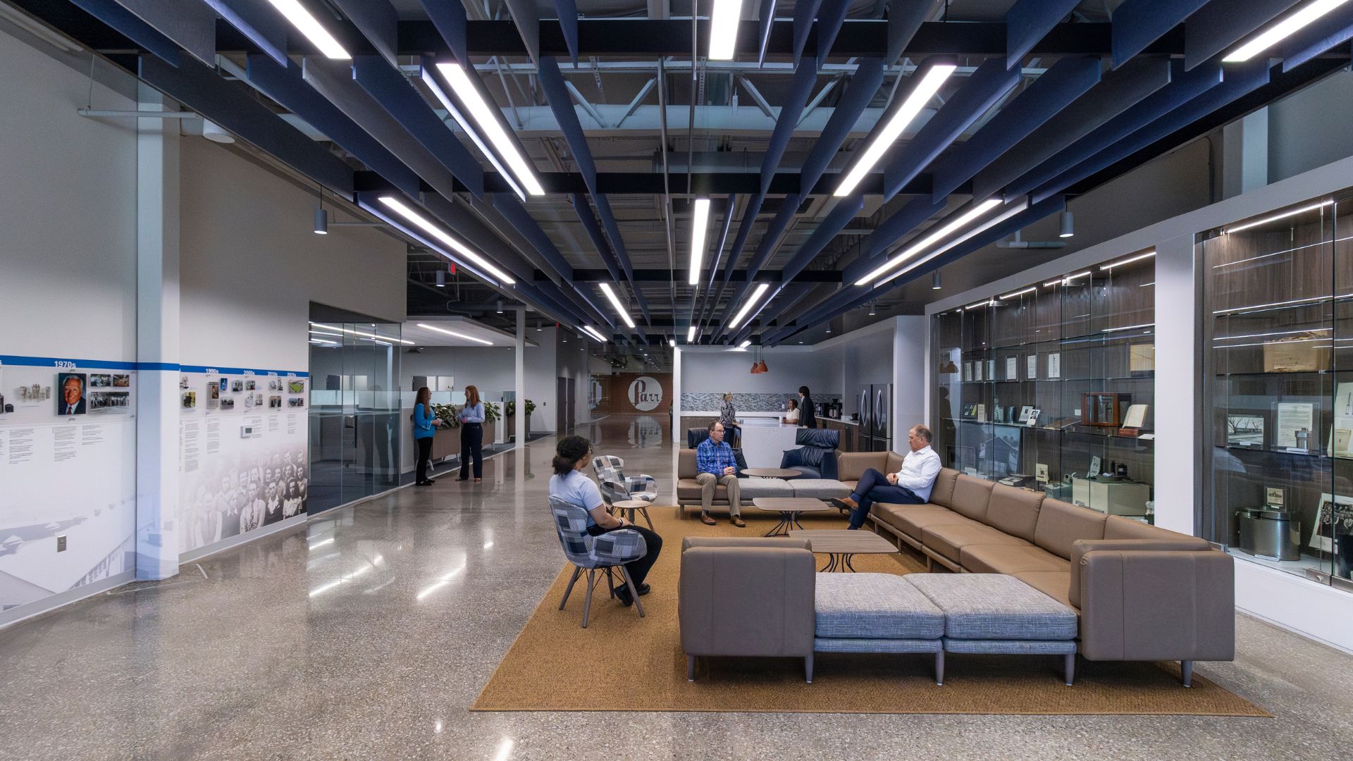Lobby of Parr Instrument Company with seating, a company history timeline wall, display cases, and a blue baffle ceiling.