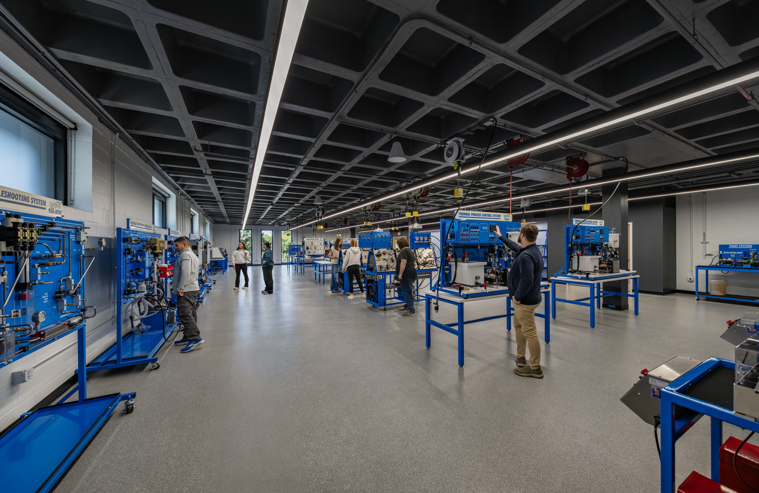 Students work at blue industrial training stations in a Black Hawk College Building 2 technology lab