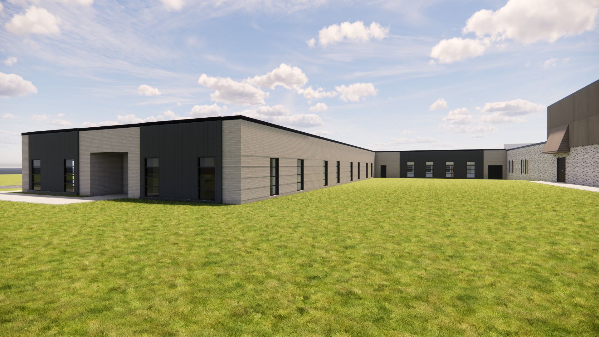 Exterior view of Bettendorf Middle School addition with beige brick and dark metal panel facade and adjacent grass field
