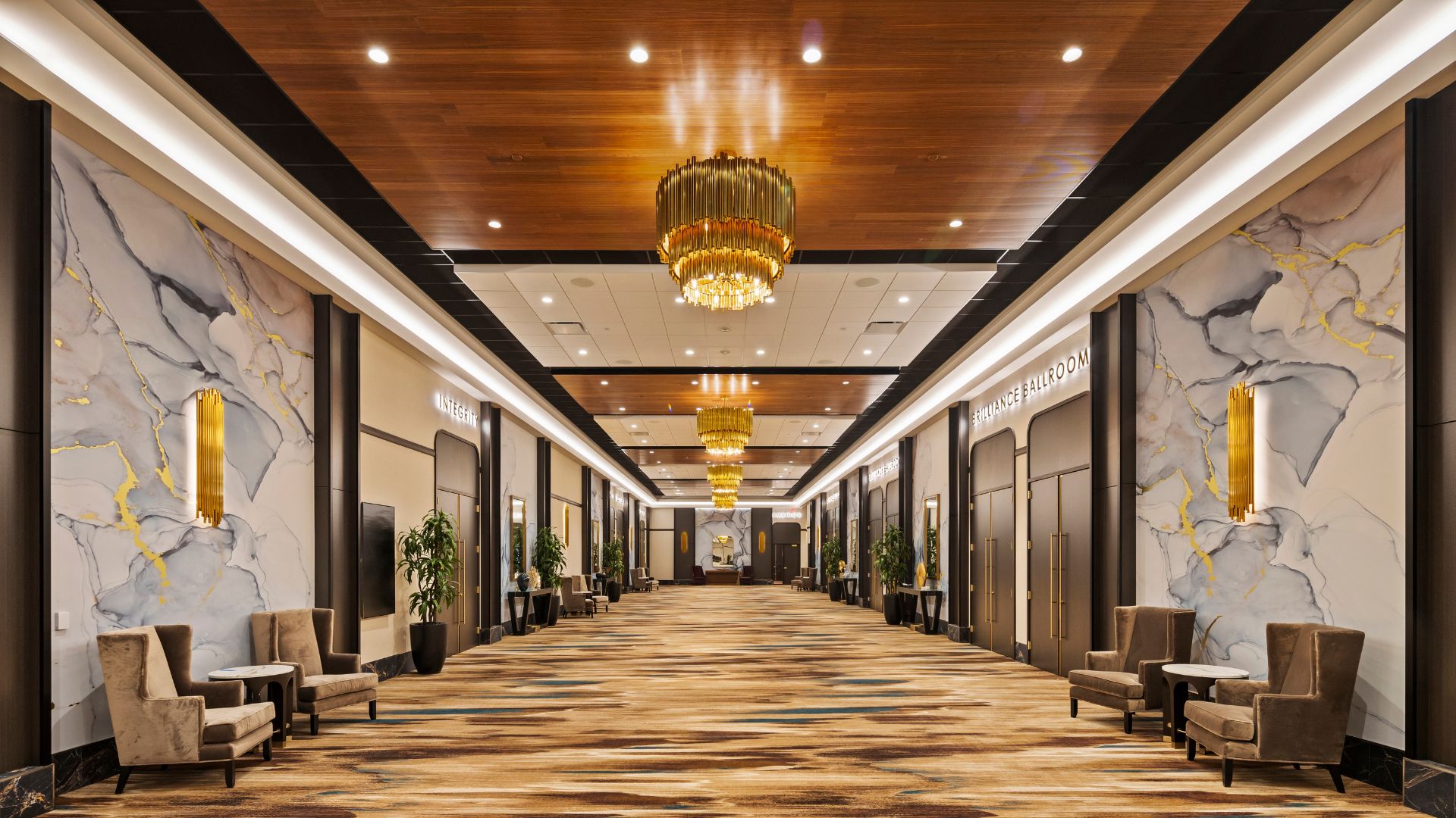 Pre-function hallway outside Brilliance Ballroom with marble walls and gold chandeliers