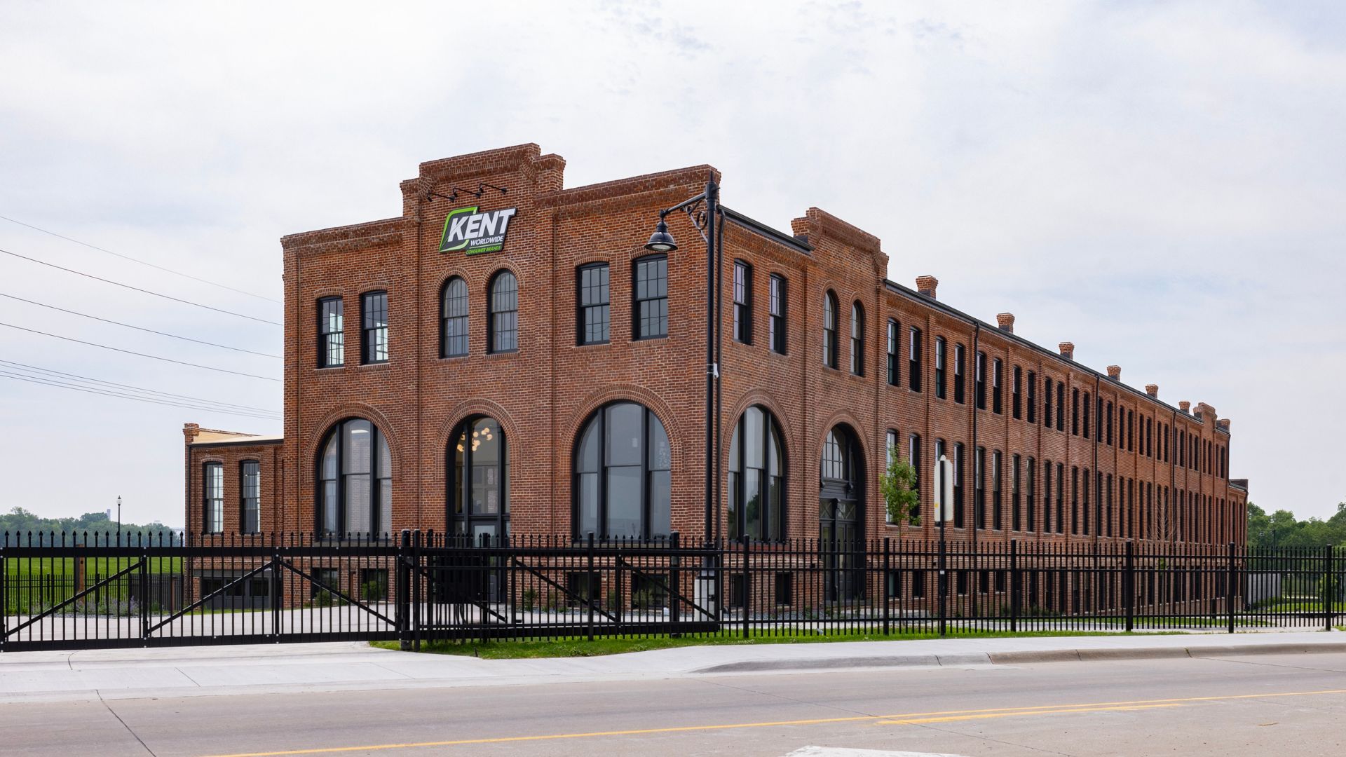 Historic McKee Building exterior in Muscatine, IA with restored brick facade, arched windows, and Kent Worldwide signage