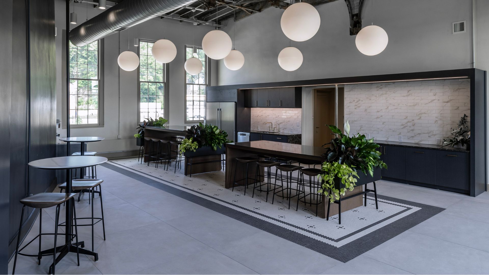 Historic engine room at McKee Building converted into kitchen and gathering space with pendant lighting and tile backsplash