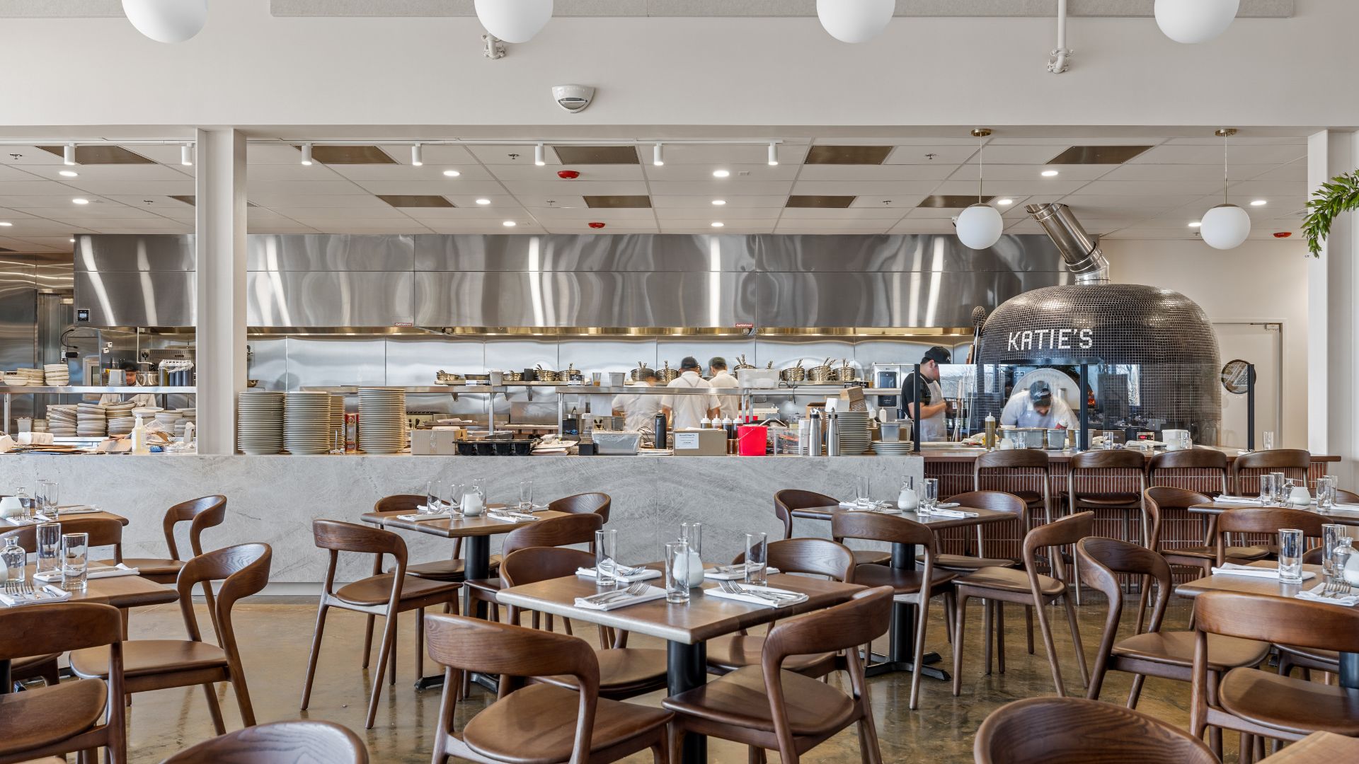 Katie's Pizza open kitchen with stainless steel finishes and tiled Katie's pizza oven