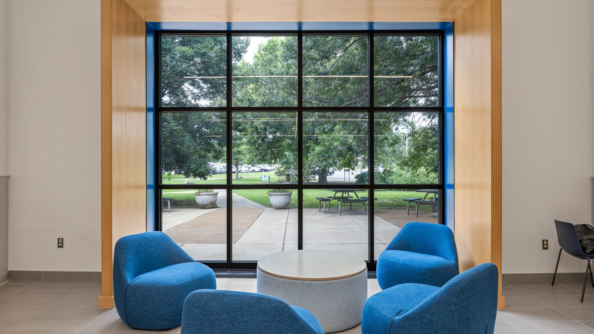 STLCC Meramec Student Center seating nook with blue chairs overlooking campus courtyard