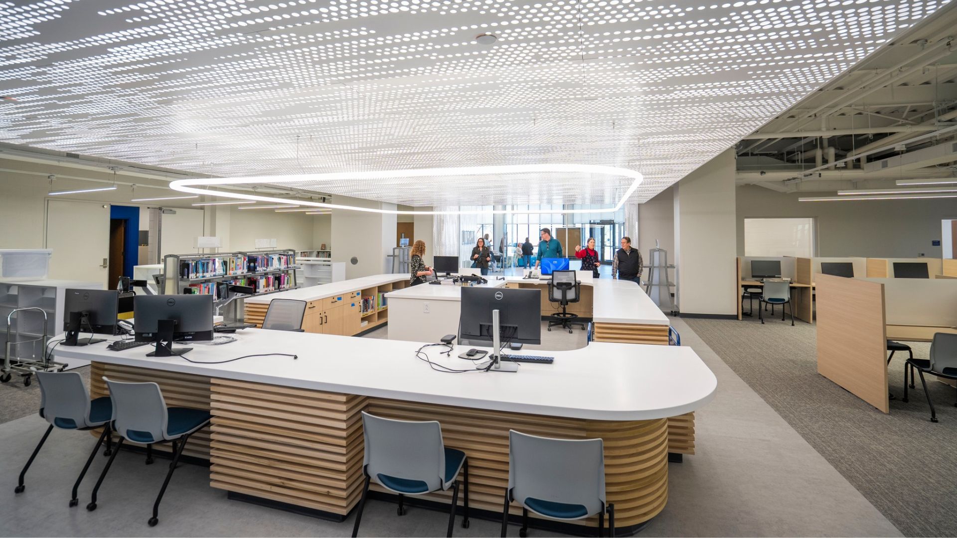 STLCC Florissant Valley library with curved wood service desk and perforated ceiling design