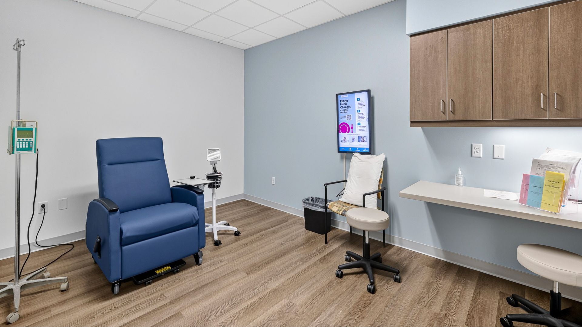 Procedure room at Gateway Gastroenterology with recliner, exam chair, and wood cabinetry