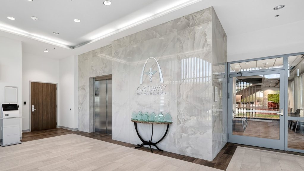 Gateway Gastroenterology lobby with marble accent wall, elevator, and entrance to seating area