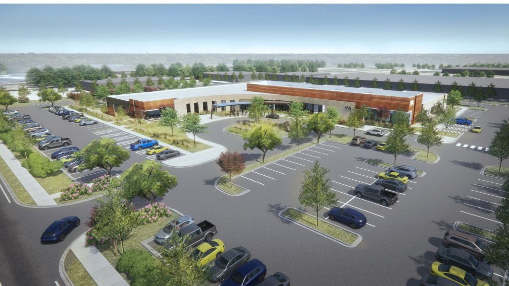 Aerial rendering of VA Outpatient Clinic in Beaumont, TX showing single-story building with metal panel and stone facade surrounded by parking lot