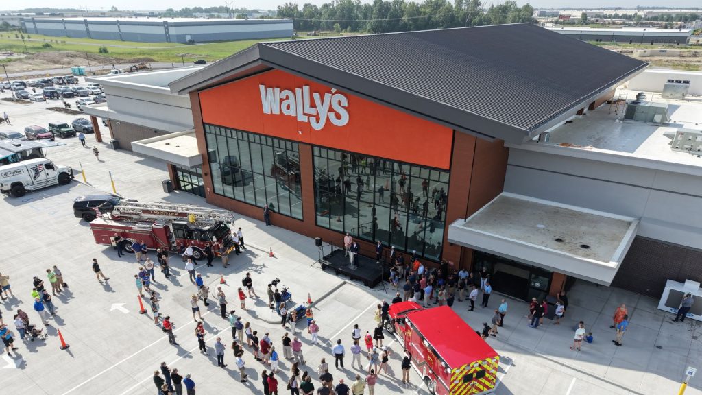 Aerial view of Wally's Travel Center grand opening with fire trucks and crowd gathered outside
